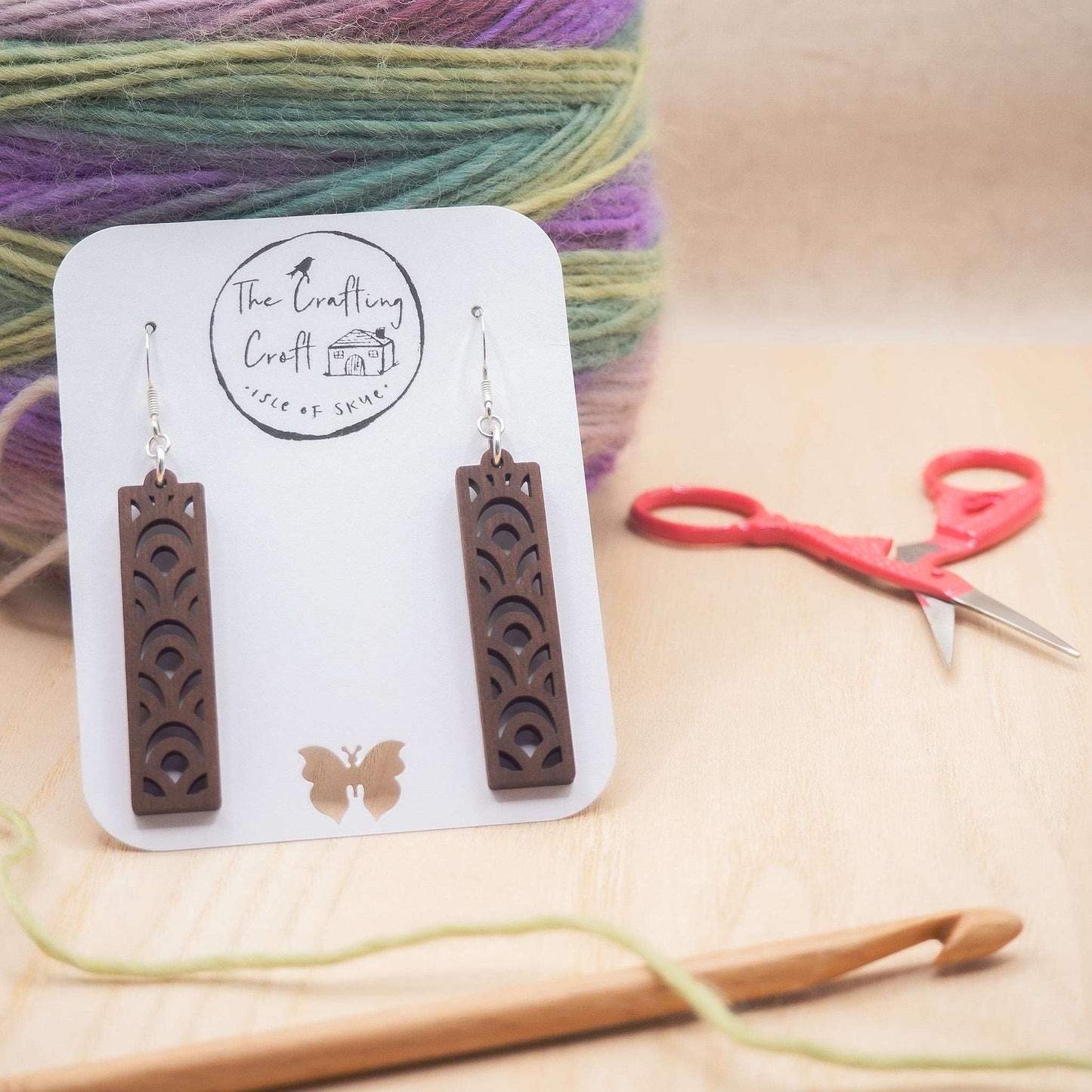Geometric design drop earrings made from walnut wood with sterling silver hooks, eco-friendly packaging.