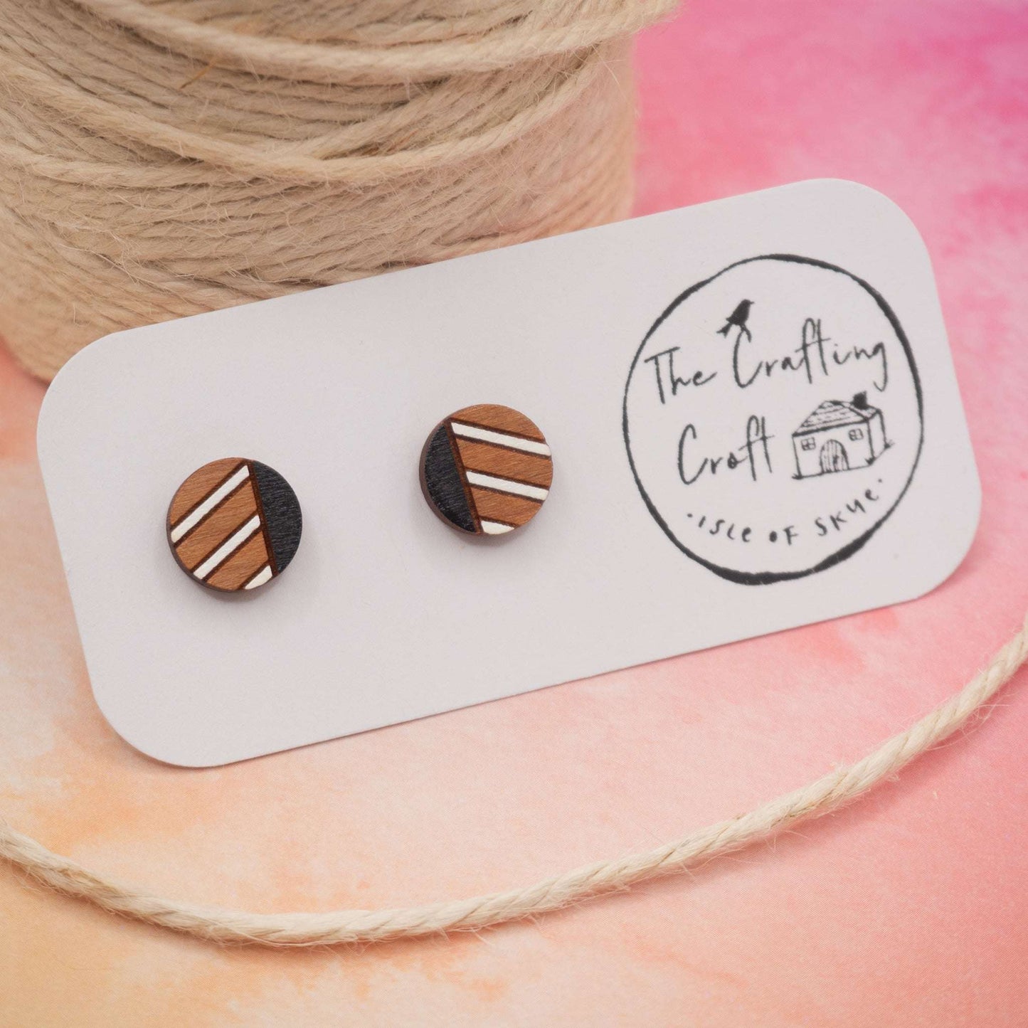 Monochrome geometric painted stud earrings made from sustainable cherry wood with black and white stripes, shown on a presentation card.