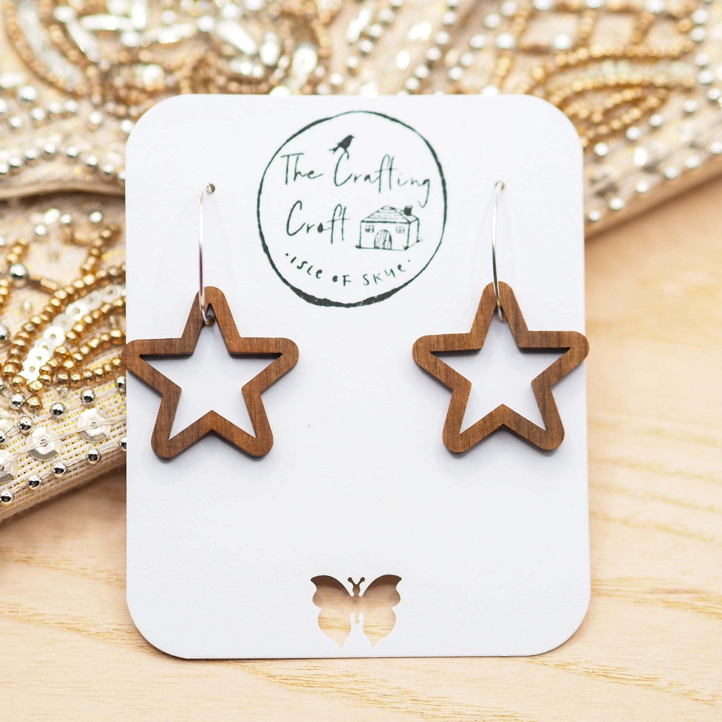 Chunky star hoop earrings made from sustainable walnut wood with sterling silver hoops, displayed on a presentation card.