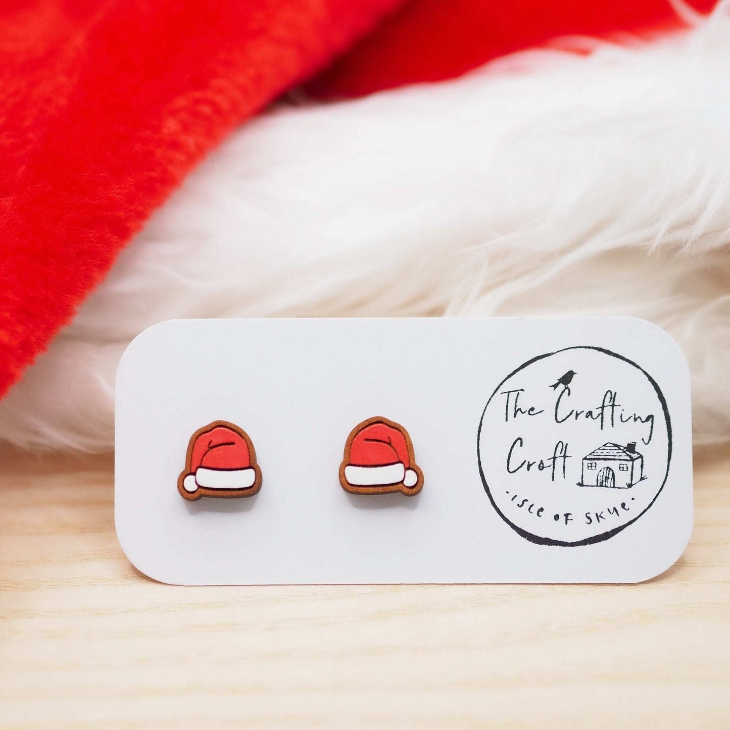 Santa hat stud earrings made from cherry wood, hand-painted and mounted on surgical steel posts.