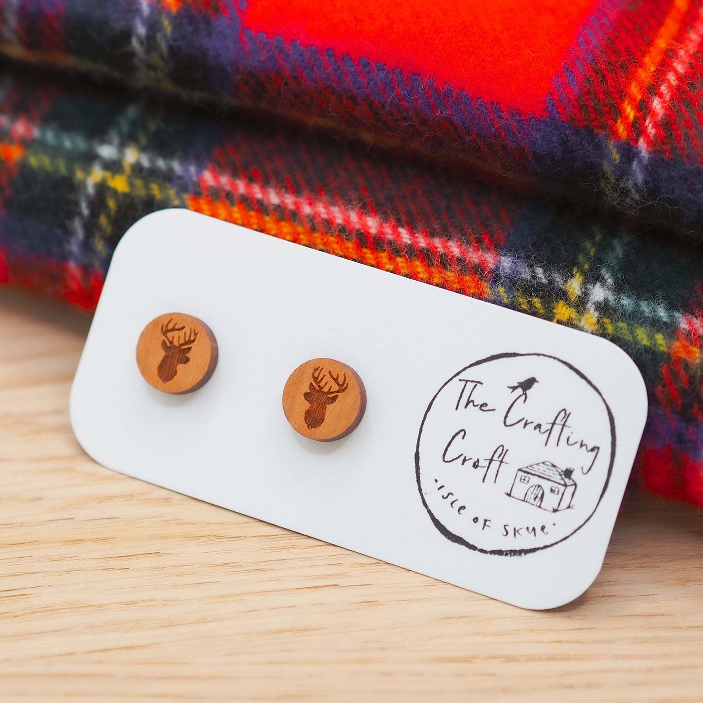 Cherry wood stag head stud earrings on surgical steel posts, eco-friendly packaging.