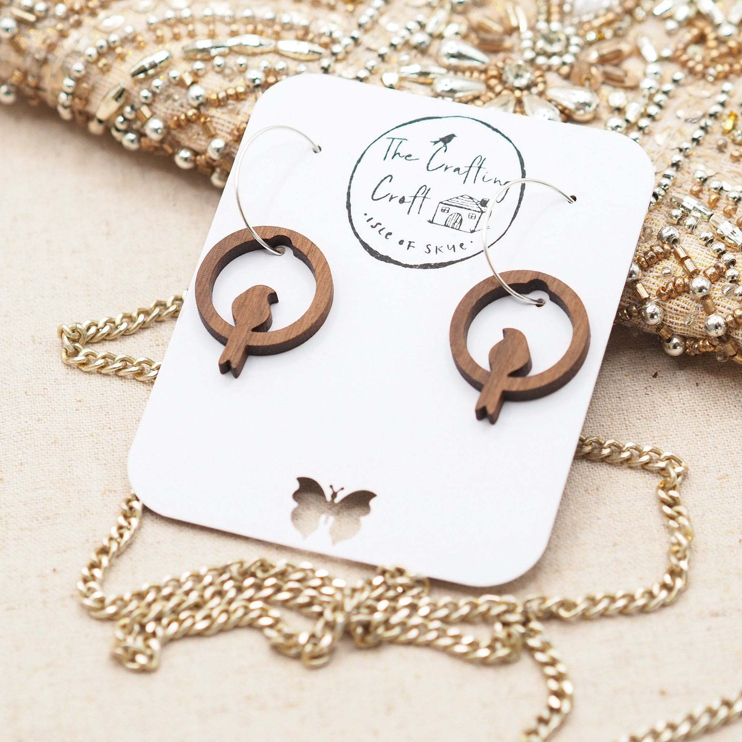 Perching bird hoop earrings made from solid walnut wood with sterling silver hoops, presented in eco-friendly packaging.
