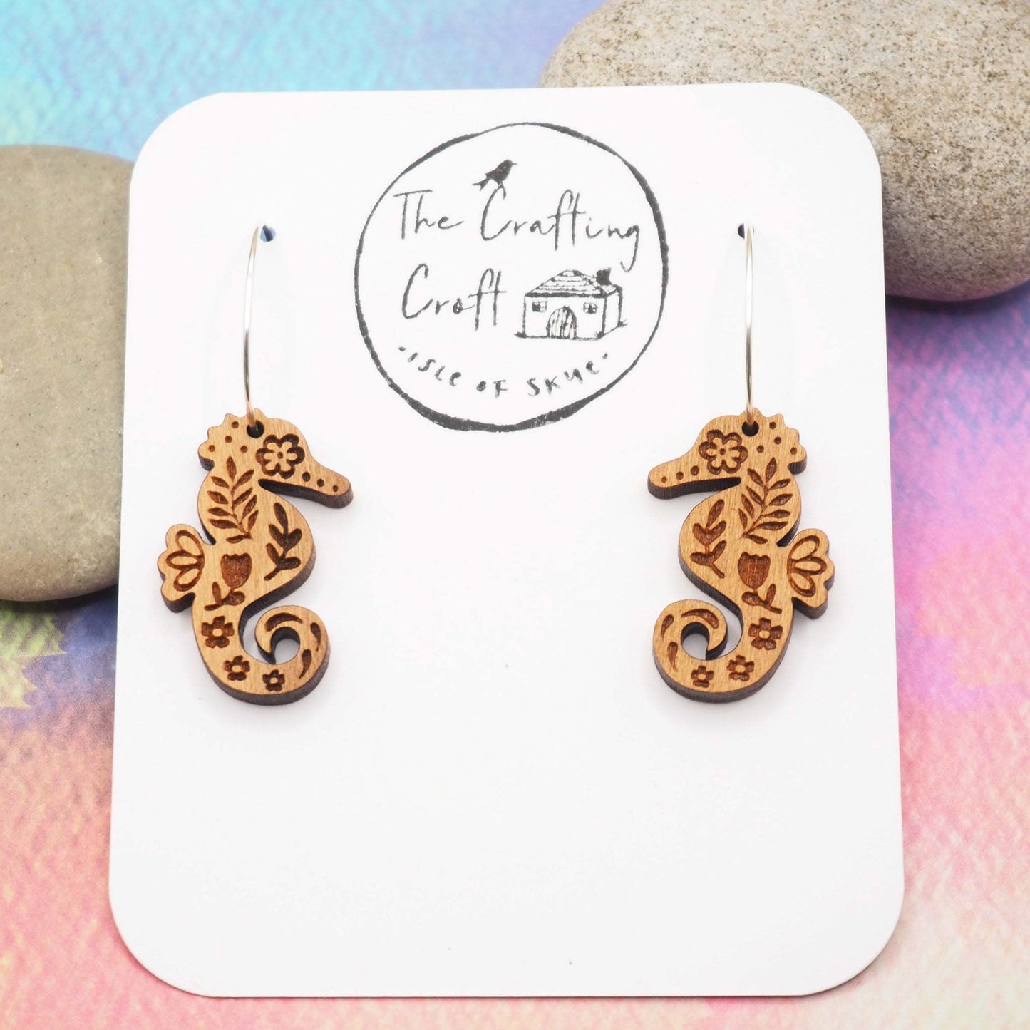 Seahorse engraved hoop earrings made from cherry wood with sterling silver hoops.