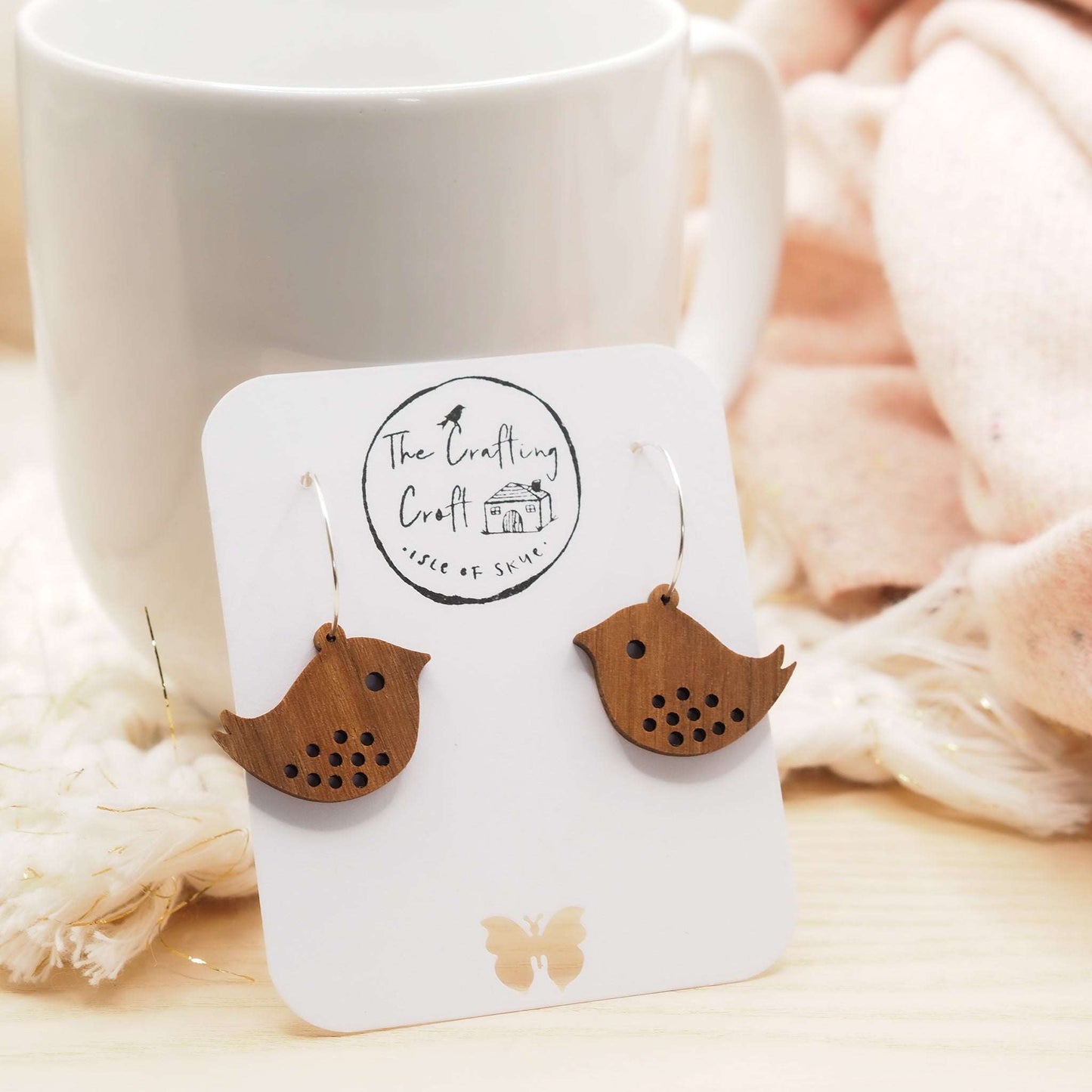 Quirky bird hoop engraved earrings made from walnut wood with sterling silver hoops displayed on a presentation card.