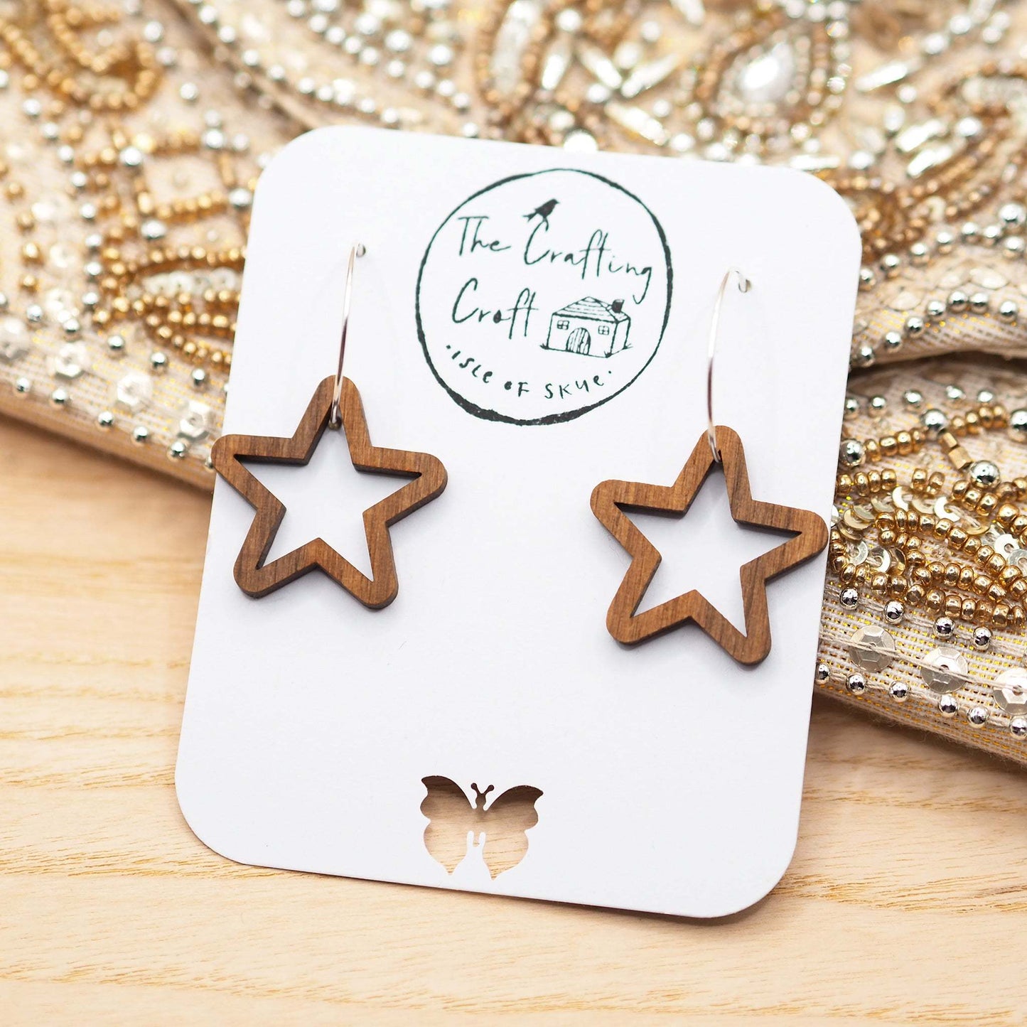 Chunky star hoop earrings made from walnut wood with sterling silver hoops, displayed on eco-friendly packaging.