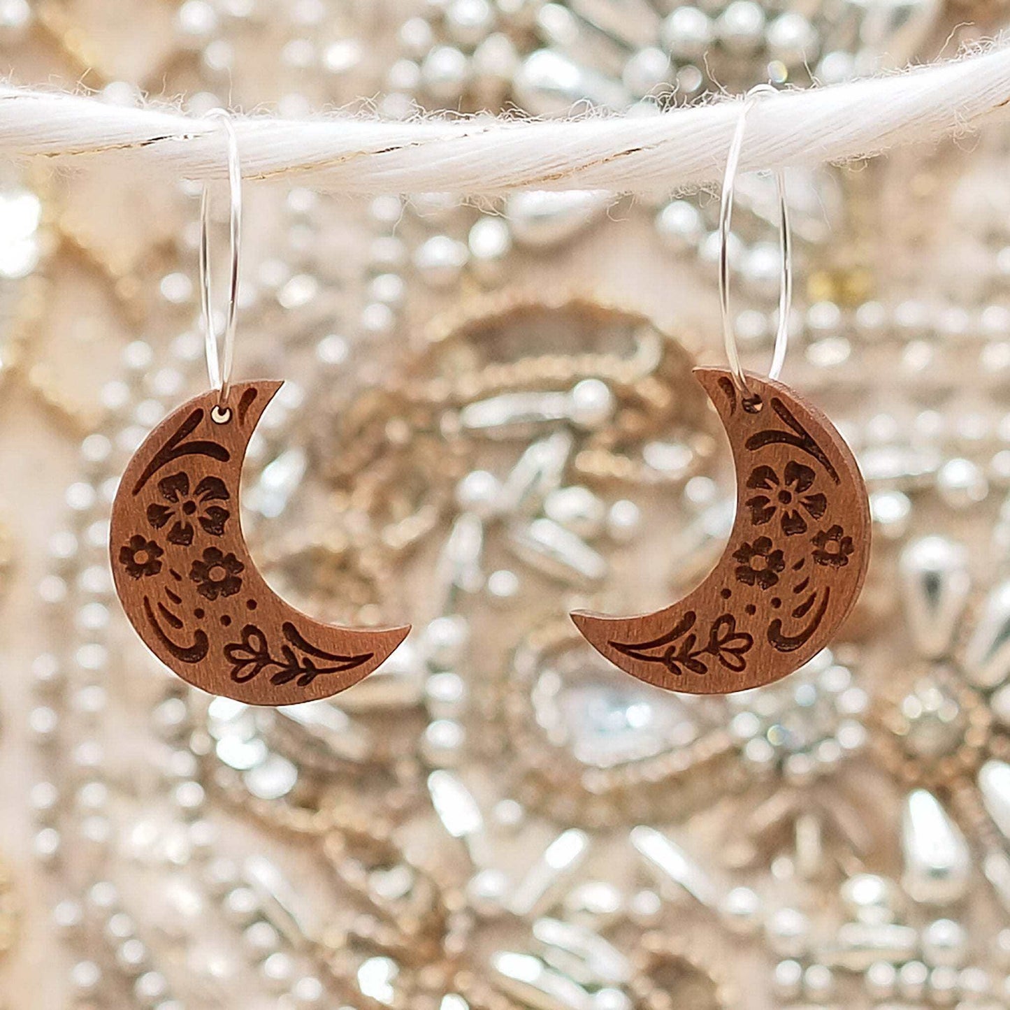 Wooden moon engraved hoop earrings with folksy pattern on sterling silver hoops.