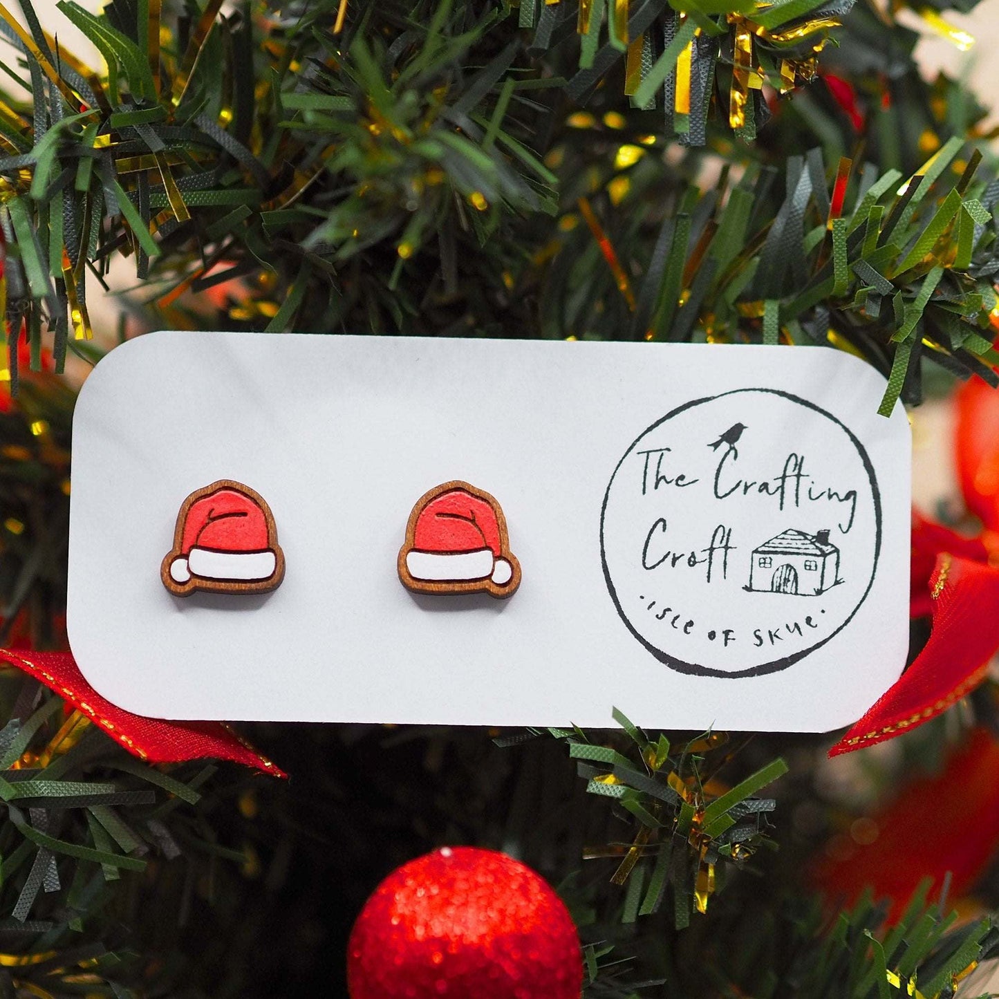 Festive Santa hat studs made from sustainable cherry wood, hand-painted, and mounted on surgical steel posts.