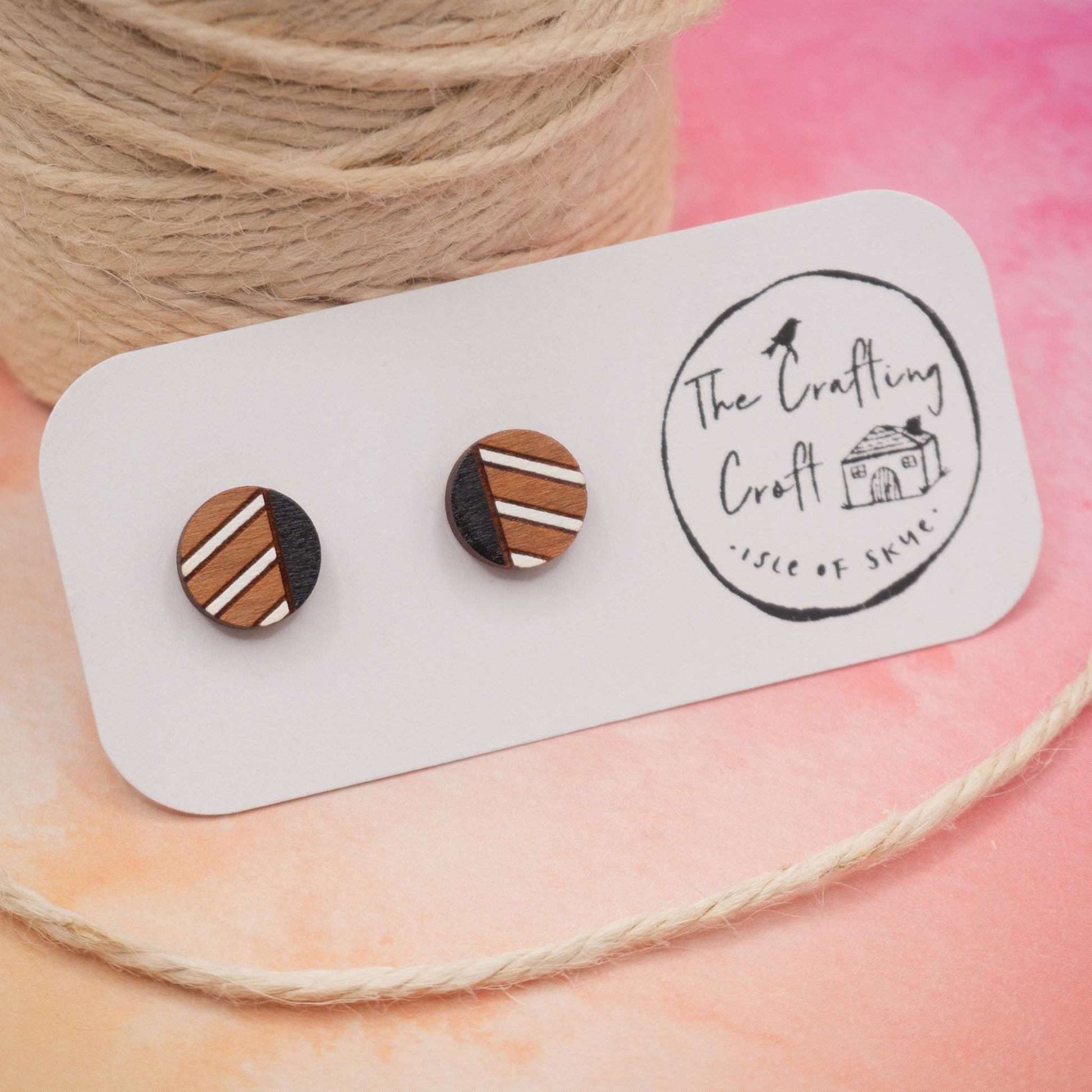 Monochrome geometric painted stud earrings made from sustainable cherry wood with black and white stripes, shown on a presentation card.