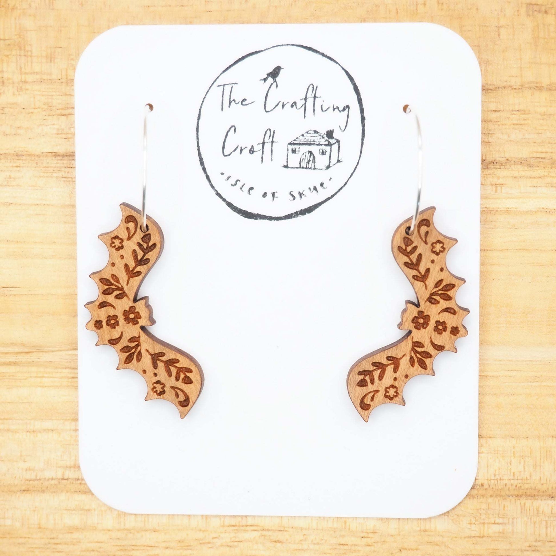 Cherry wood bat hoop earrings with intricate engraving on sterling silver hoops.