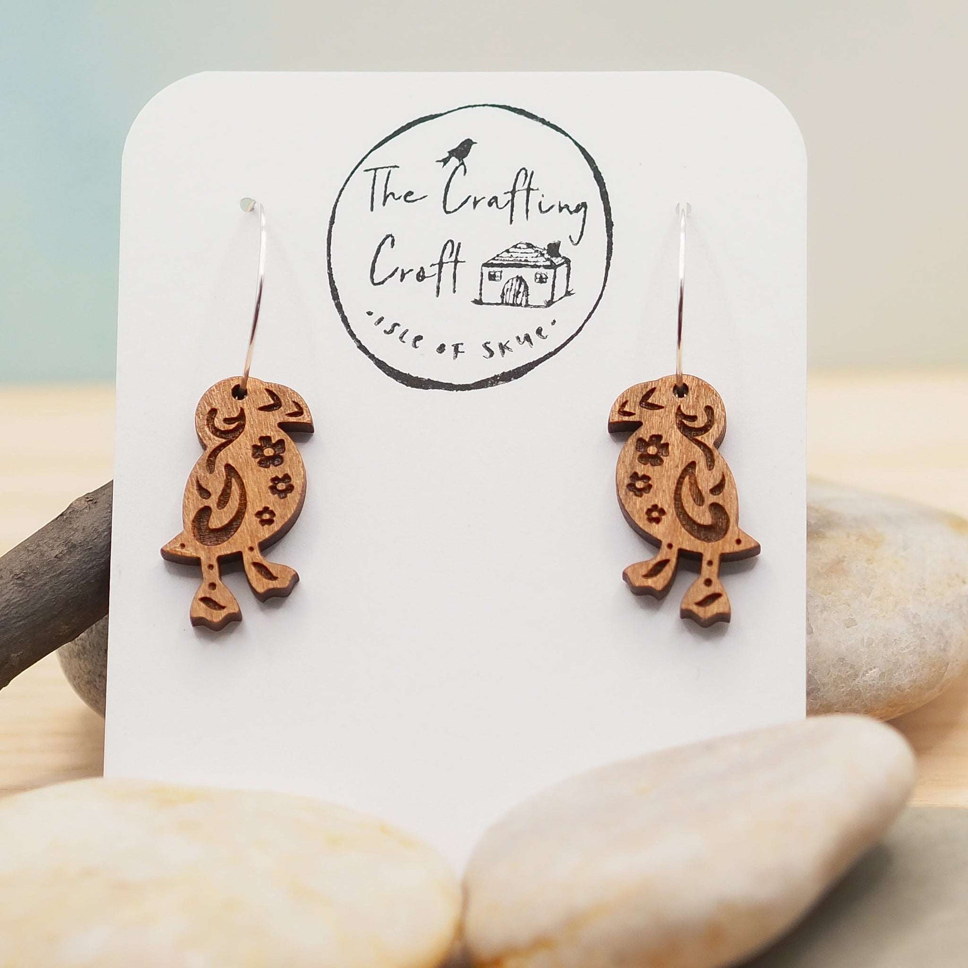 Wooden puffin engraved hoop earrings with sterling silver hoops on display in eco-friendly packaging.