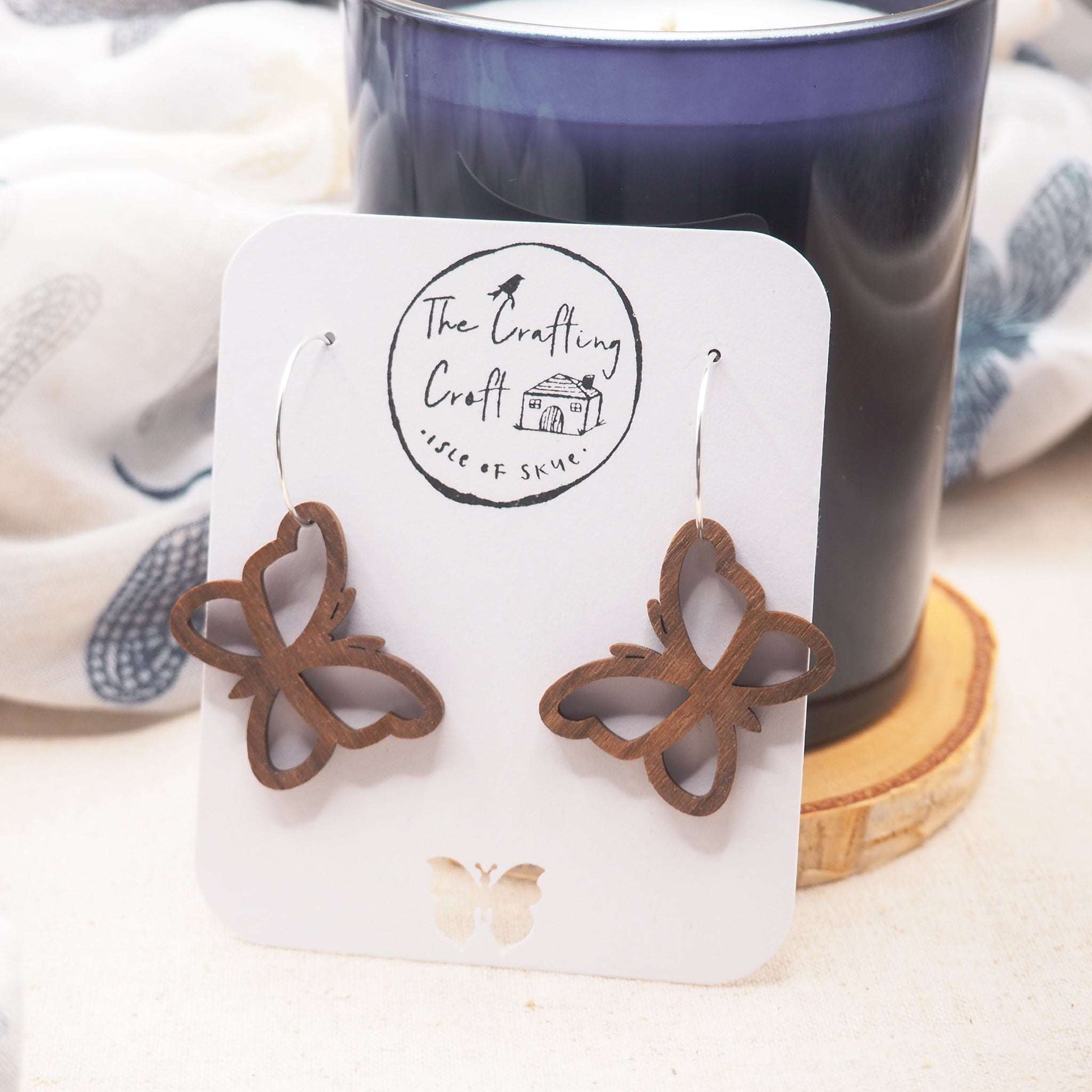 Butterfly outline hoop earrings made from walnut wood and sterling silver.