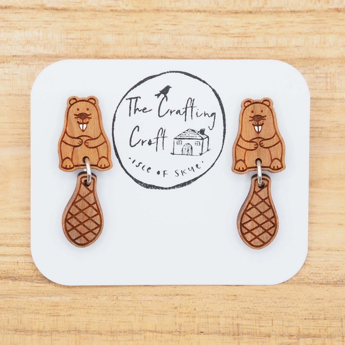 Beaver stud earrings made of hand-painted cherry wood with surgical steel posts and sterling silver jump rings, featuring dangling beaver tail design.