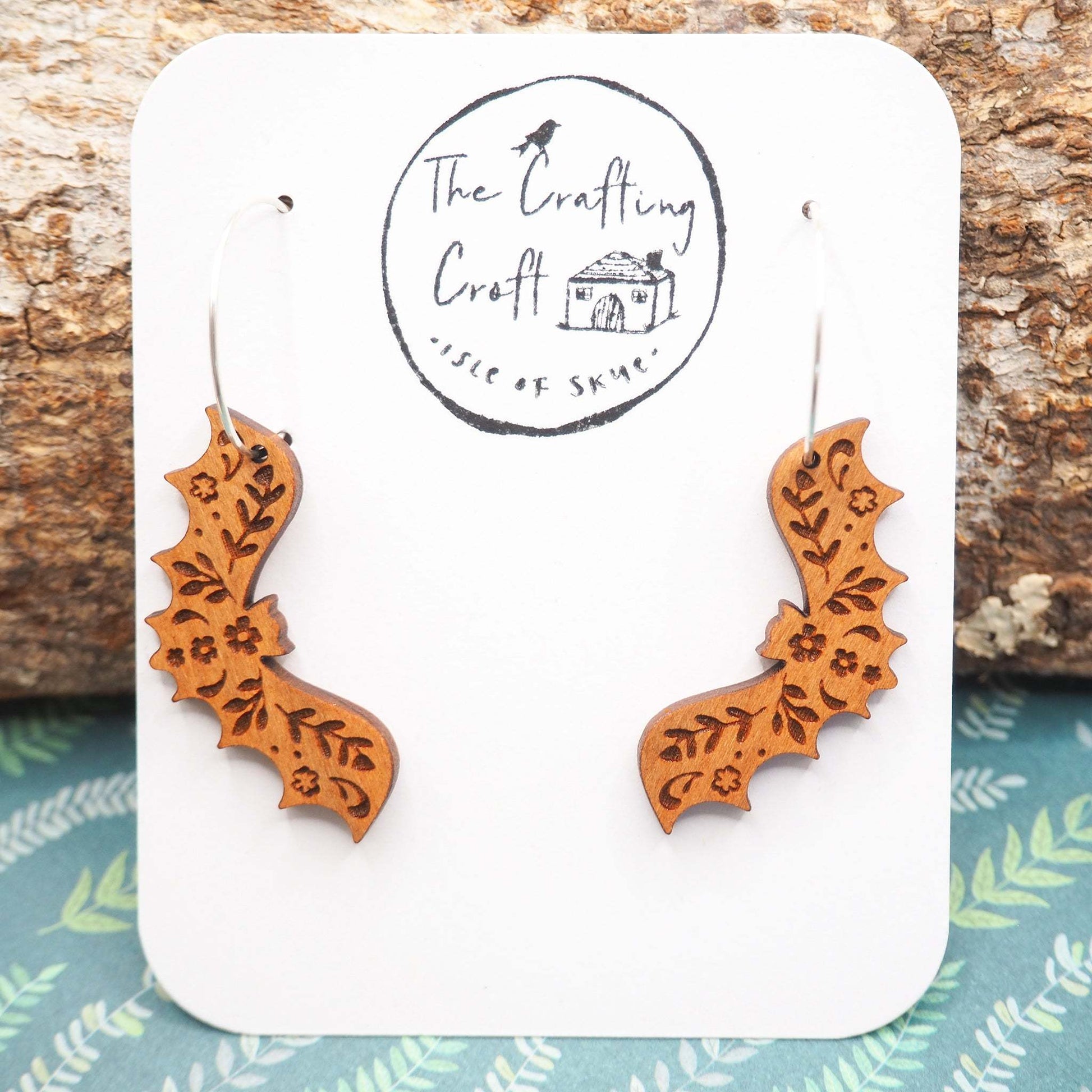 Unique bat hoop earrings with intricate laser-cut cherry wood design, eco-friendly varnish, and sterling silver hoops.