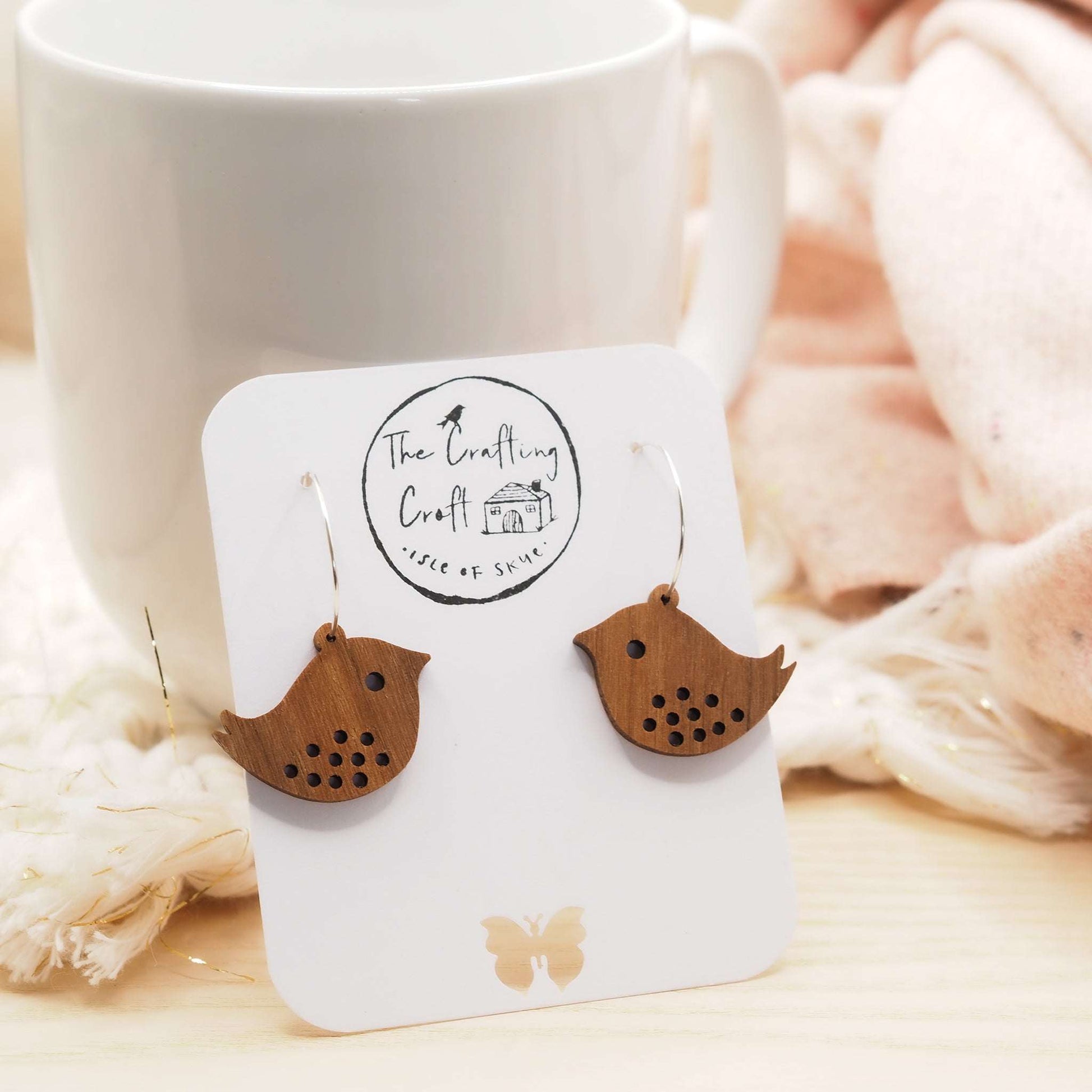 Quirky bird hoop engraved earrings made from walnut wood with sterling silver hoops displayed on a presentation card.