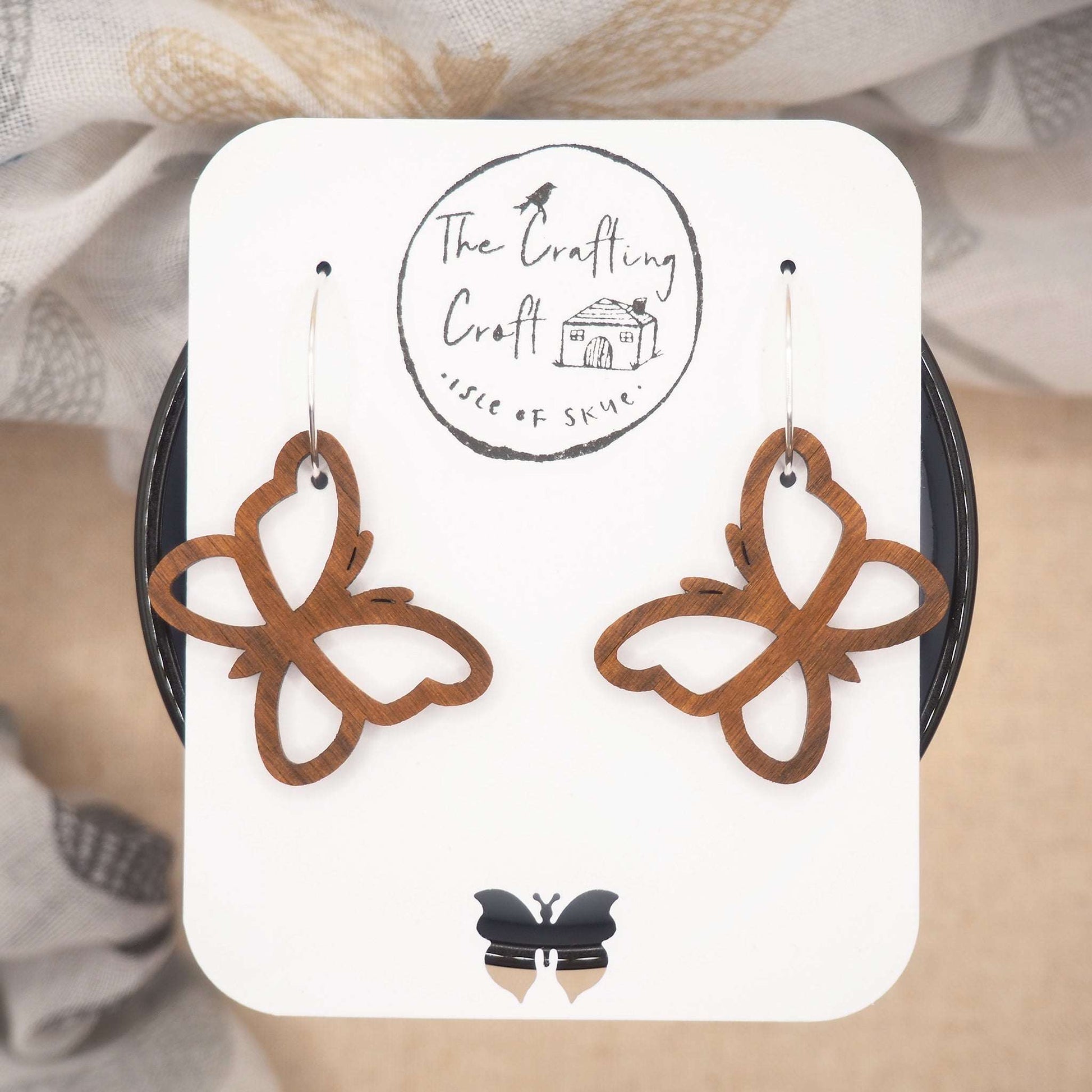 Butterfly outline hoop earrings made from walnut wood on sterling silver hoops.