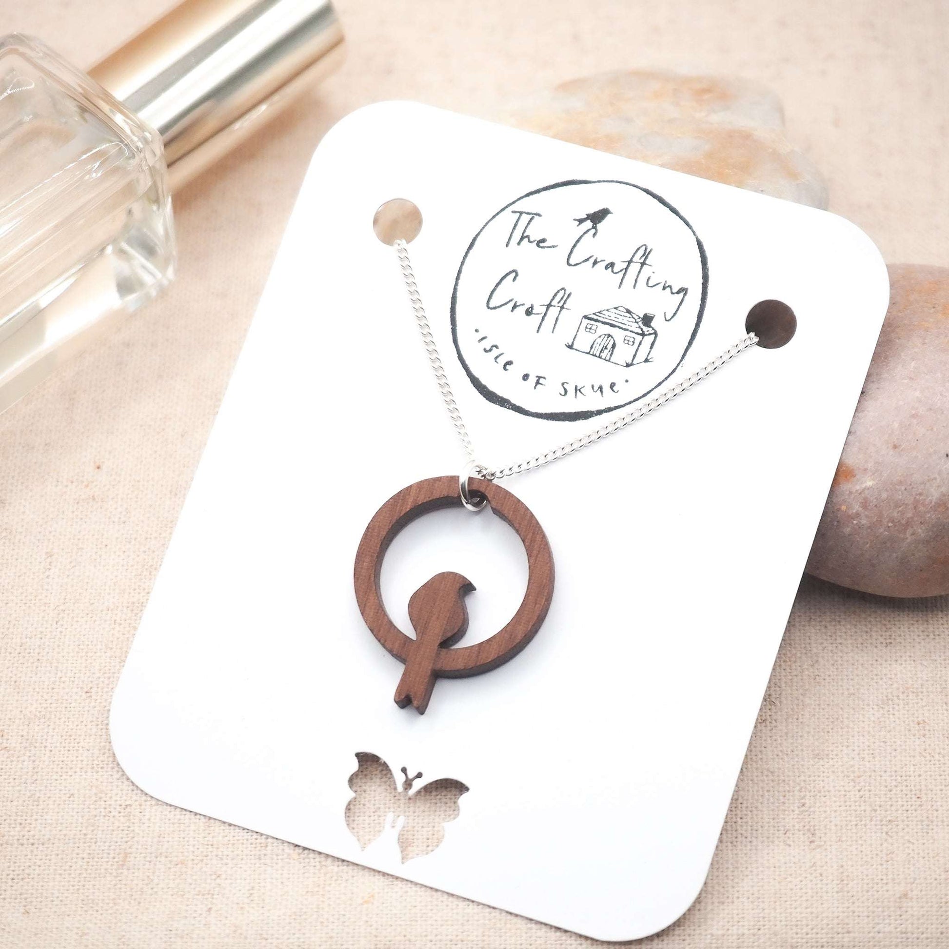 Wooden bird hoop necklace with sterling silver chain, eco-friendly packaging.