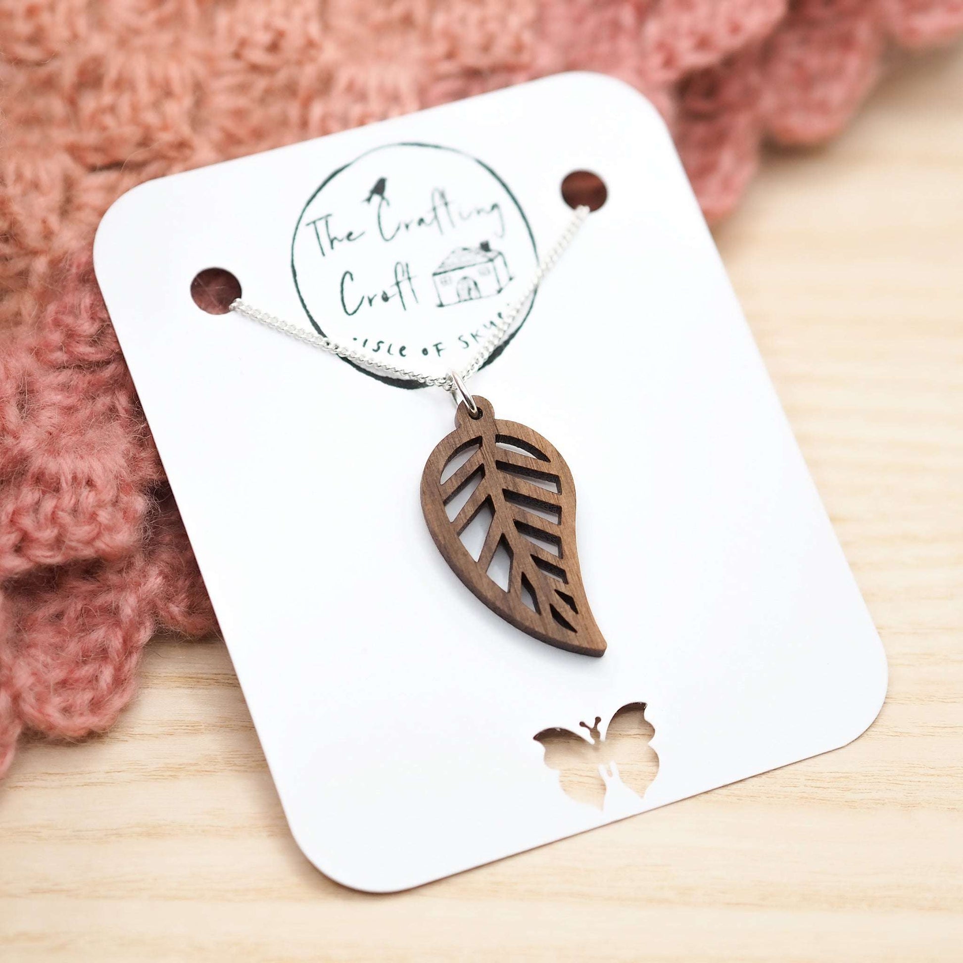 Laser-cut walnut leaf outline necklace on recycled silver chain.