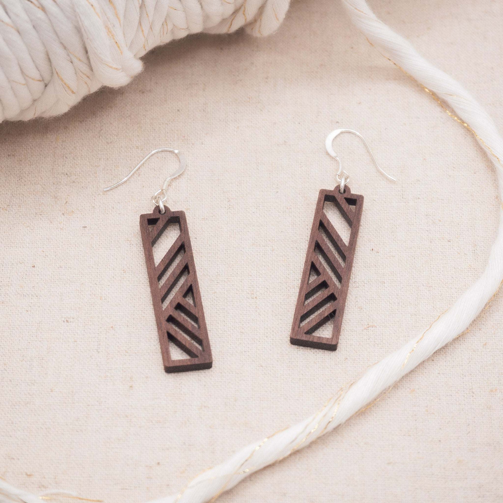 Geometric stripe drop earrings made from walnut wood with sterling silver hooks.