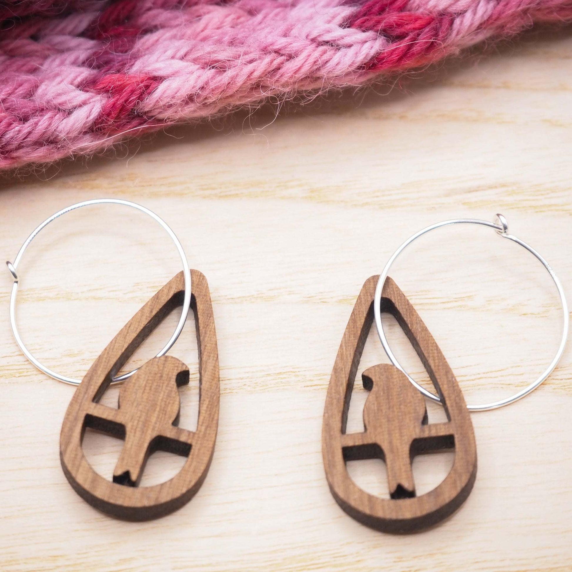Perching bird teardrop hoop earrings in walnut wood and sterling silver hoops.