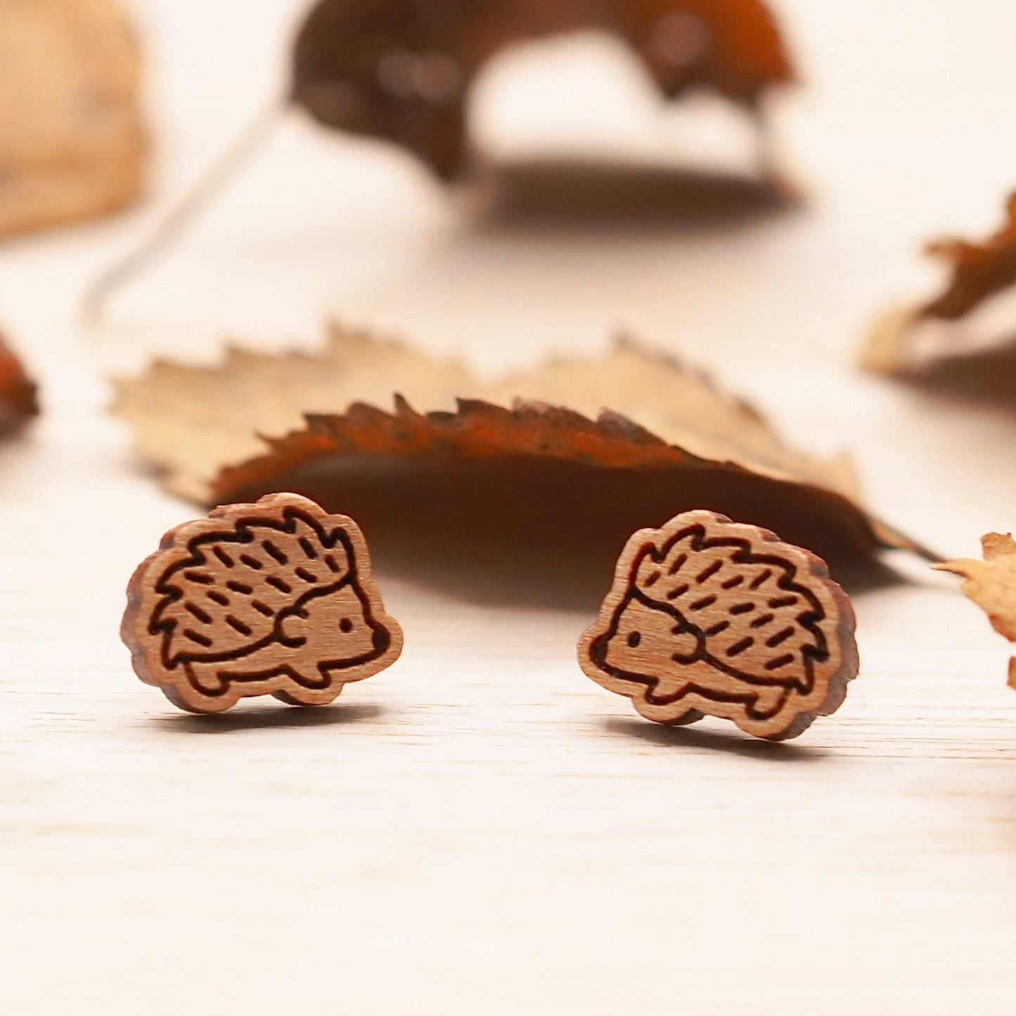 Wooden hedgehog stud earrings made from cherry wood with surgical steel backing.