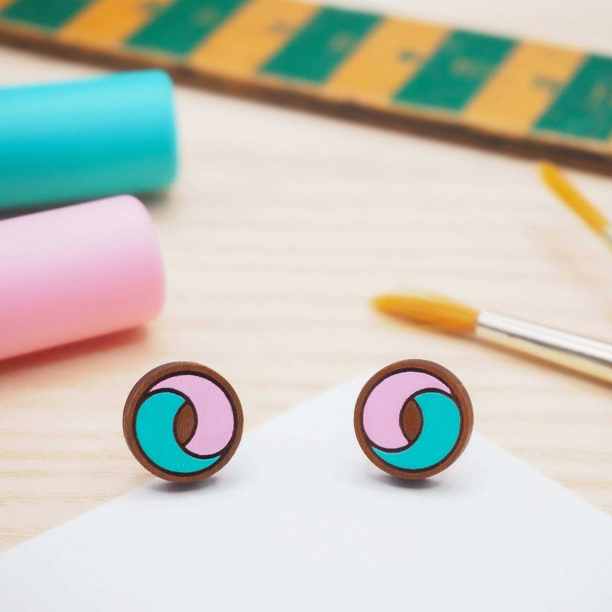 Pink and turquoise swirl stud earrings made from cherry wood.