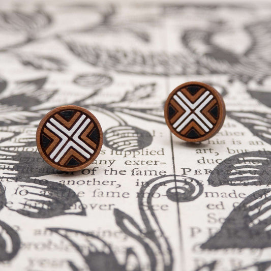 Black and white geometric painted studs on patterned background.