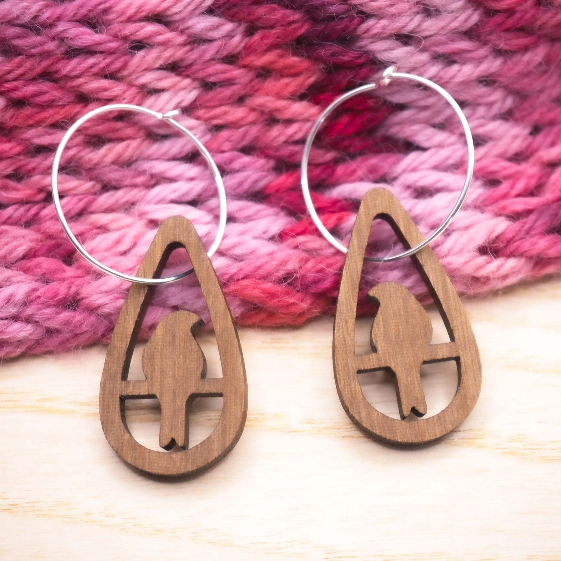 Perching bird teardrop hoop earrings made from walnut wood with sterling silver hoops.