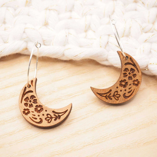 Wooden moon engraved hoop earrings with intricate folksy pattern on cherry wood and sterling silver hoops.