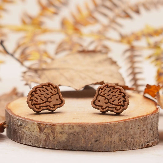 Wooden hedgehog stud earrings on display, laser cut from cherry wood with eco-friendly packaging.