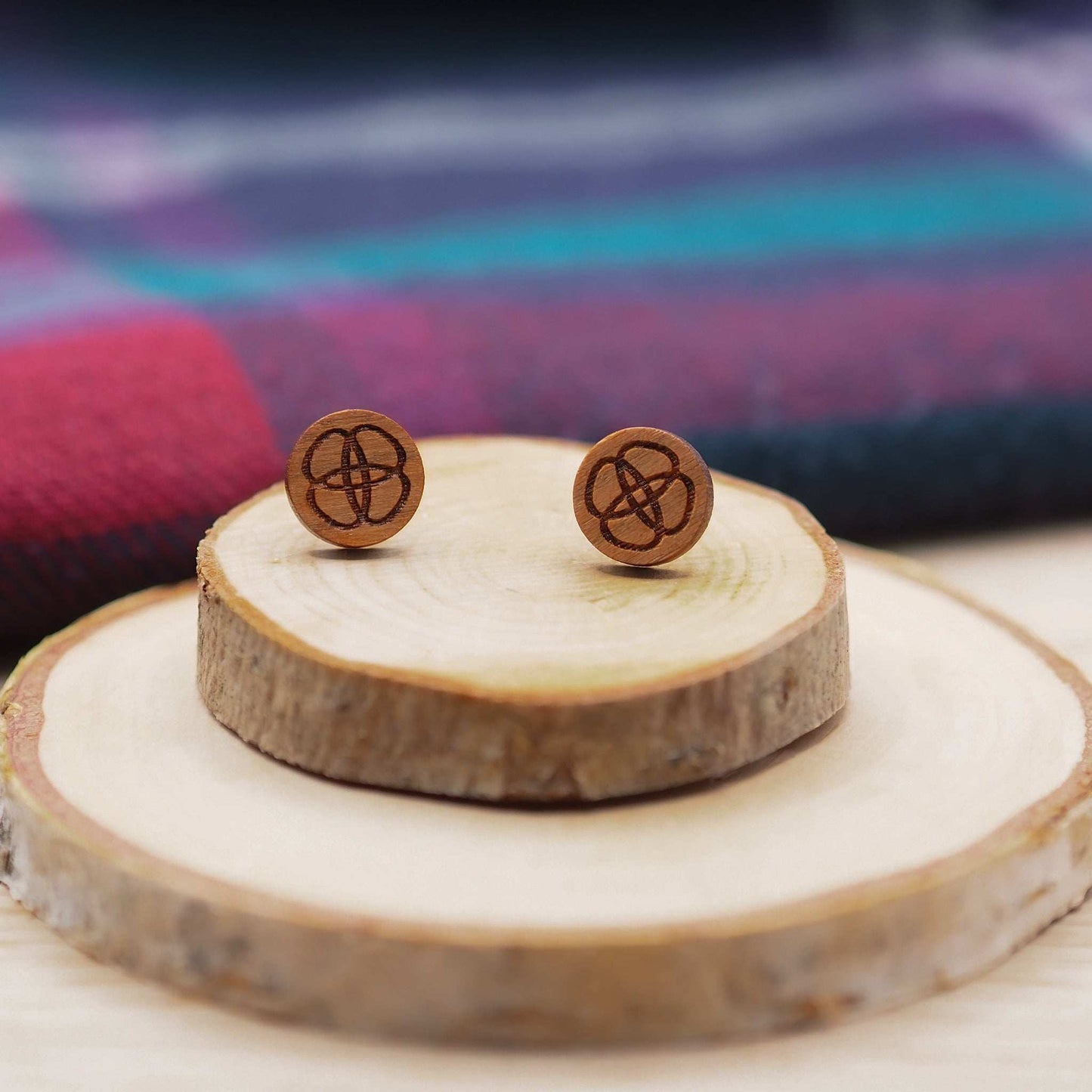 Celtic flower knot stud earrings made of cherry wood with surgical steel backs, displayed on wooden holders.