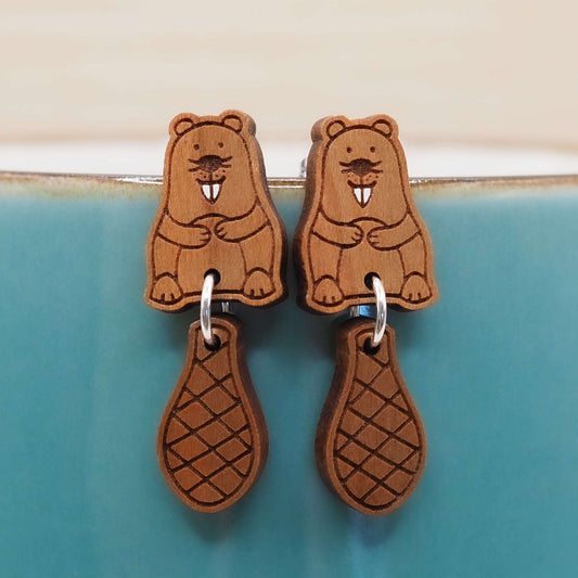 Cherry wood beaver stud earrings with dangling tails on surgical steel posts.